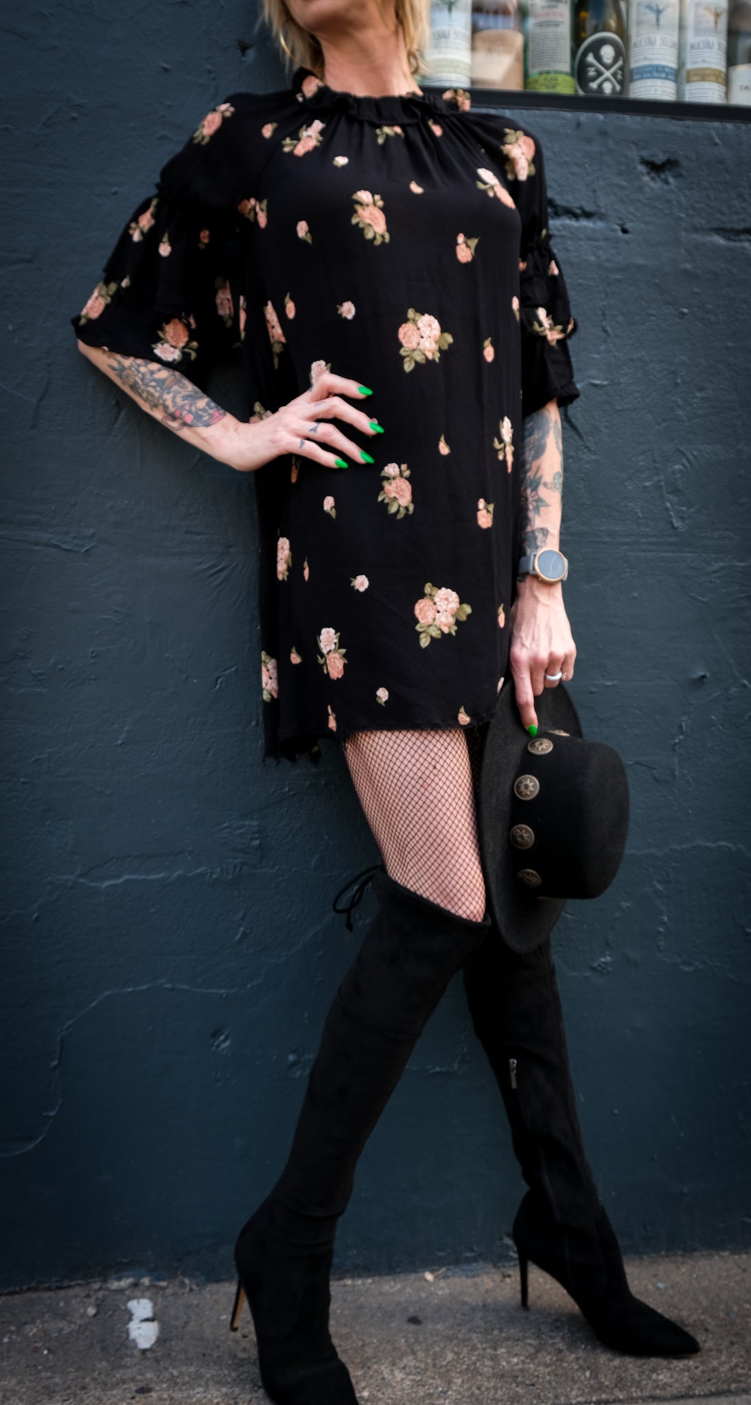Model wearing a casual flowy black and floral dress matched with high boots